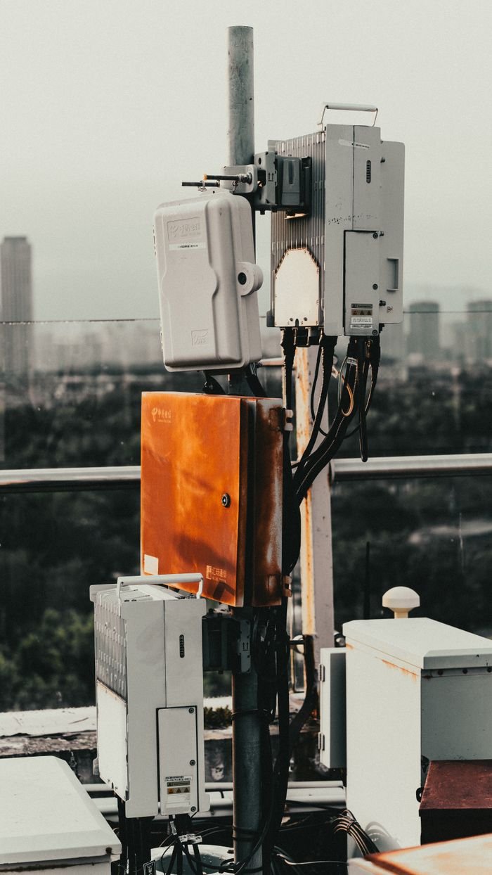 Telecommunication devices on a rooftop in Xiamen, China, with cityscape background.